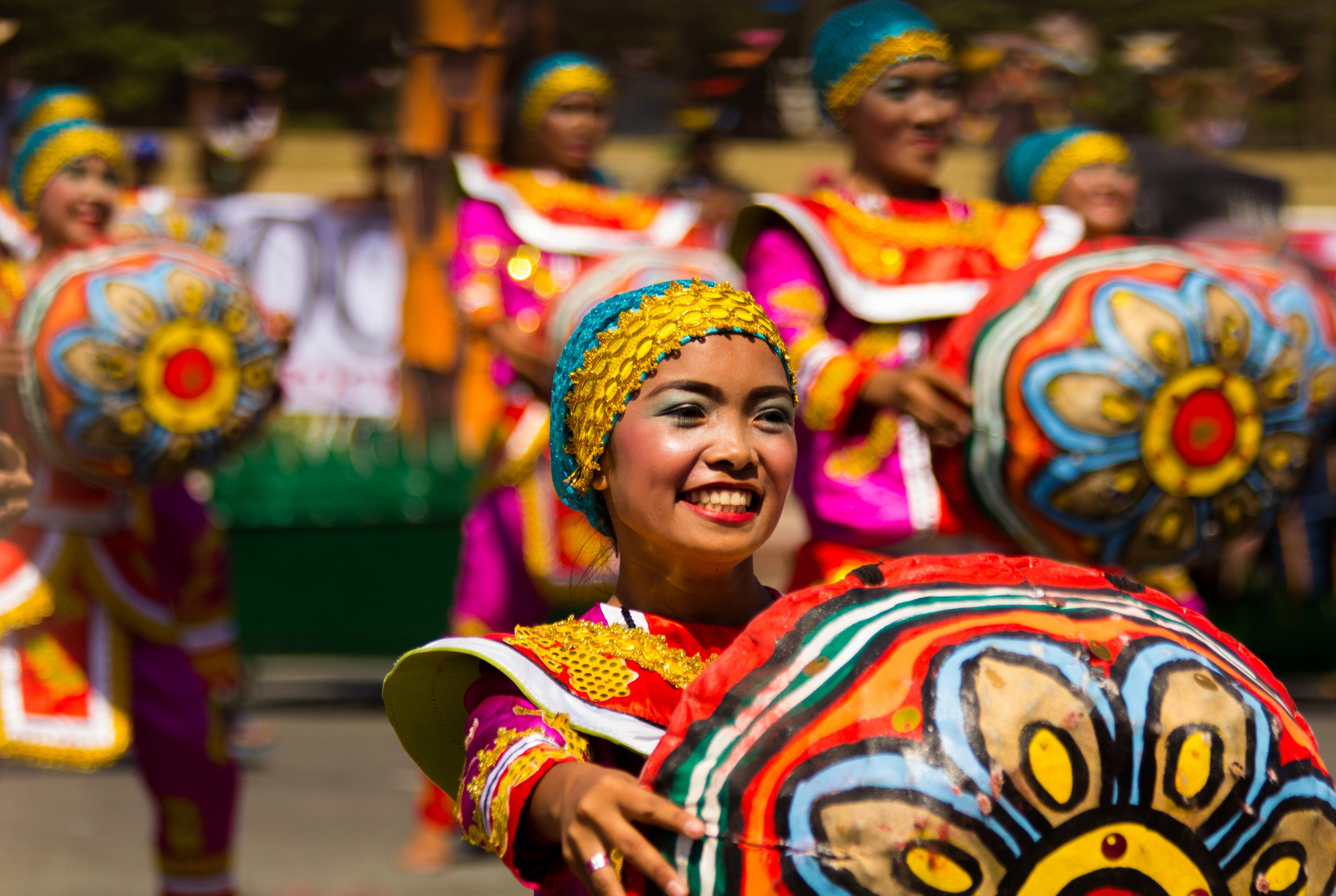 ΟΠαρέλαση από κοπέλες στις Φιλιππίνες με πολύχρωμες στολές που κρατάνε στα χέρια τους τύμπανα με ωραία σχέδια