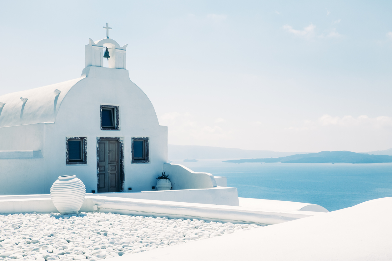 Παραδοσιακή ελληνική εκκλησία σε λευκό χρώμα, στη Σαντορίνη, Ελλάδα. Φόντο το απέραντο γαλάζιο.