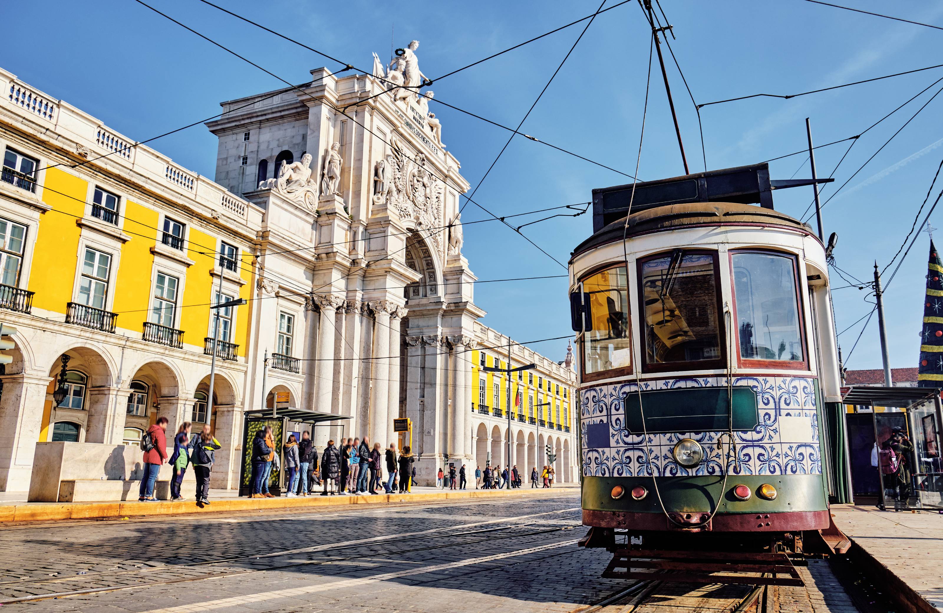Παραδοσιακό τραμ σε δρόμο στη Λισσαβόνα, Πορτογαλία περνά δίπλα από κίτρινο κτίριο