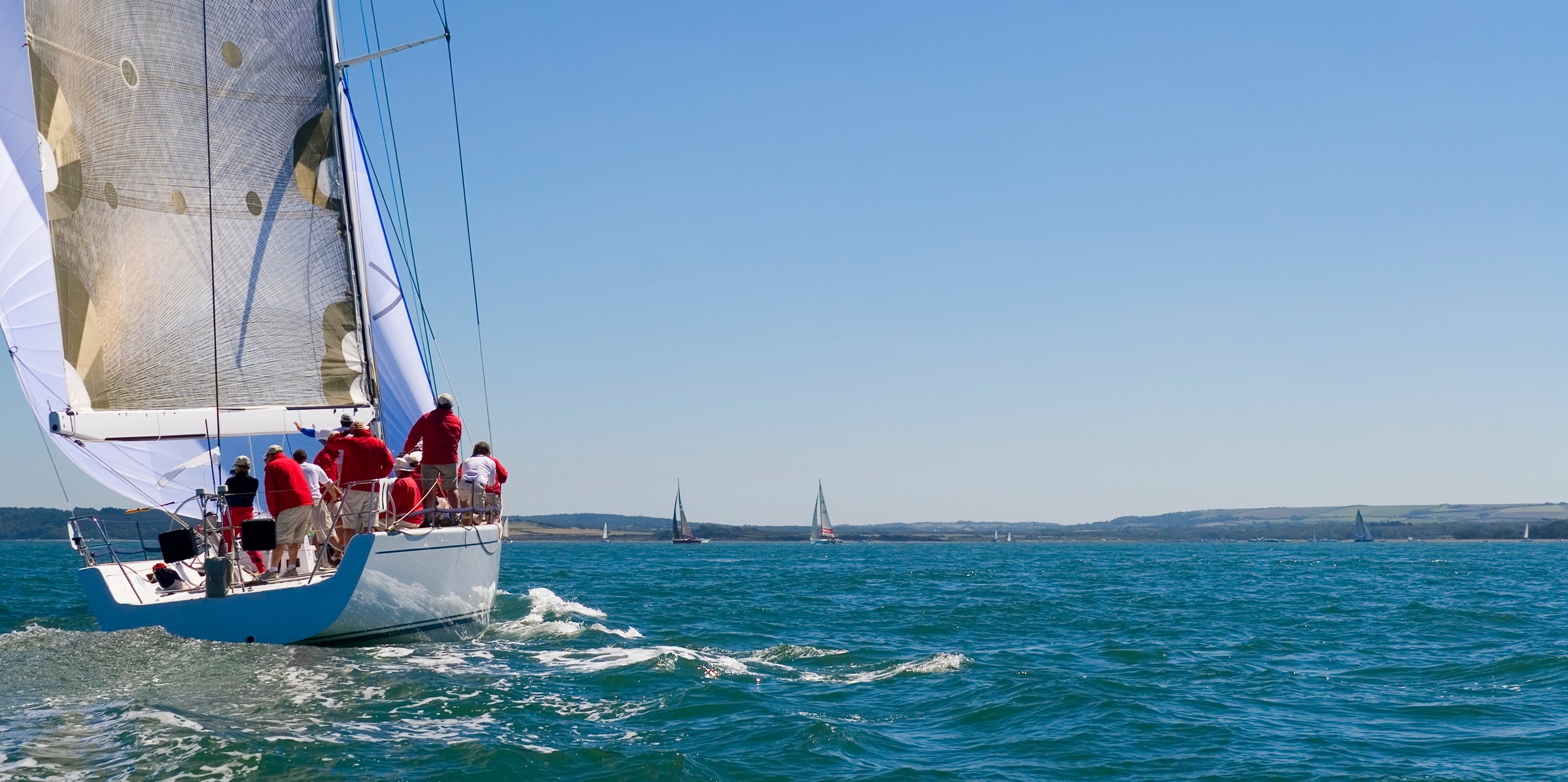 A fully crewed racing yacht sailing