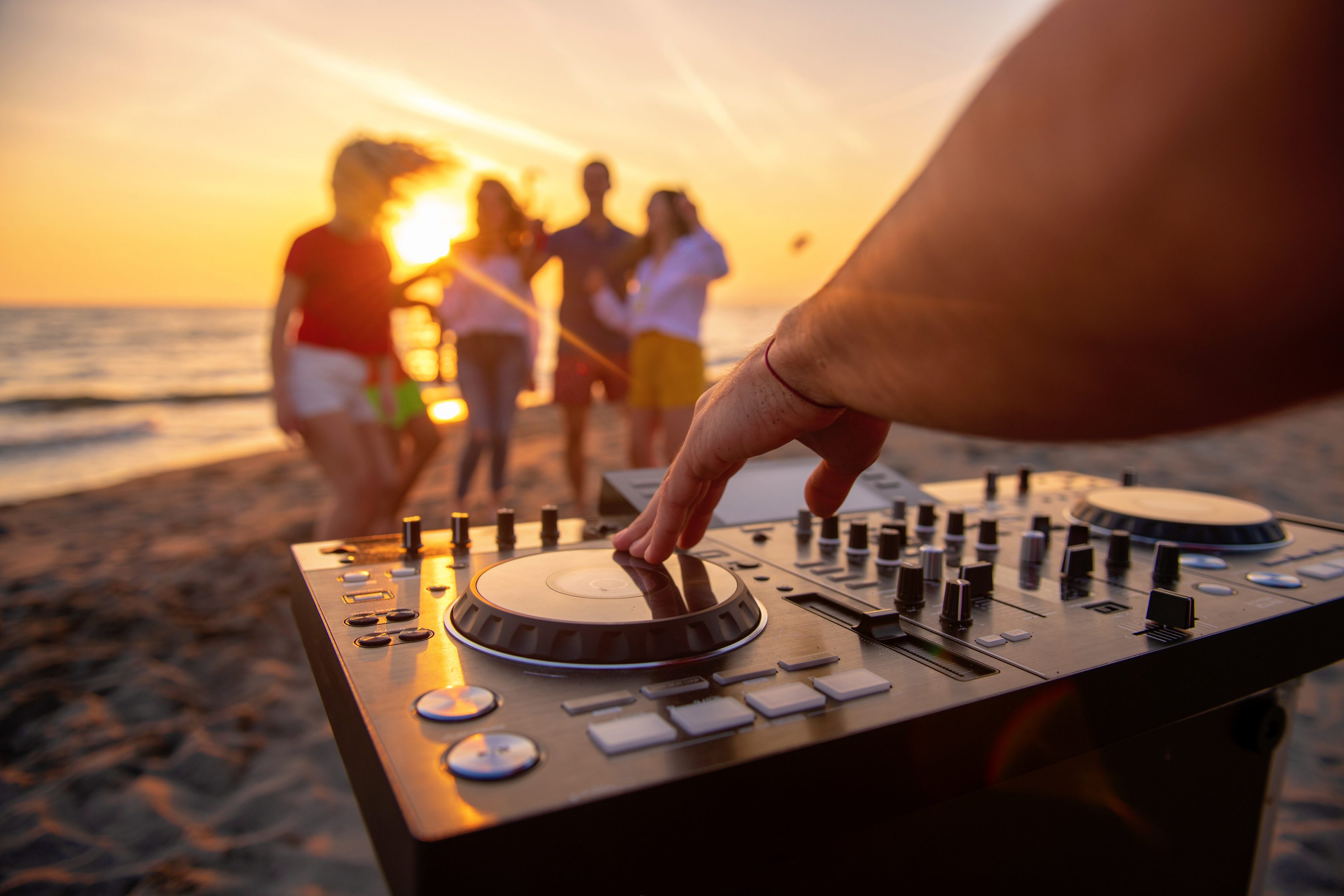 Ένα πάρτυ με φίλους που χορεύουν στην παραλία και ο dj παίζει μουσική