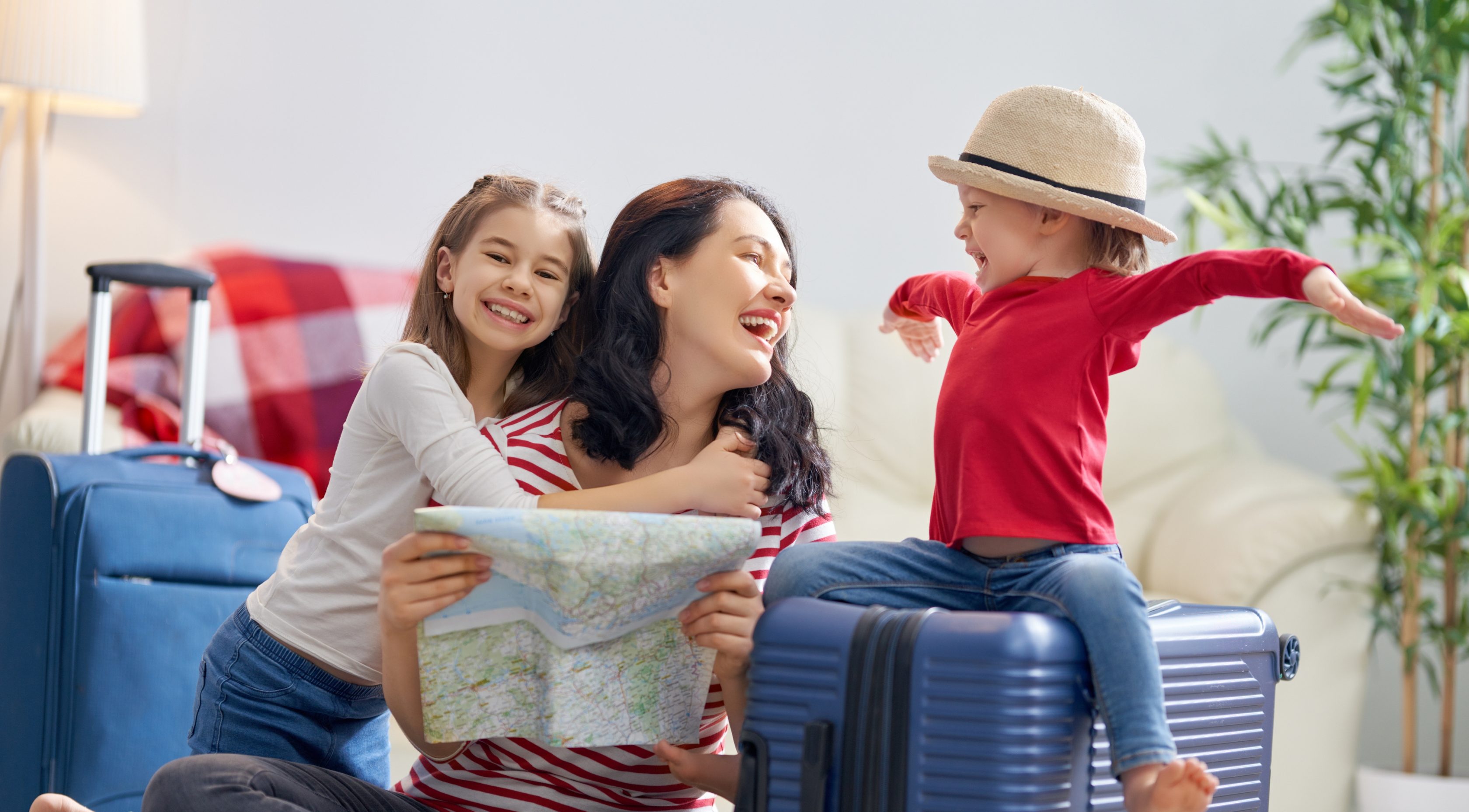 Μια χαρούμενη οικογένεια προετοιμάζεται για το ταξίδι. Η μαμά και οι κόρες της φτιάχνουν τις βαλίτσες τους και κοιτάνε τον χάρτη.