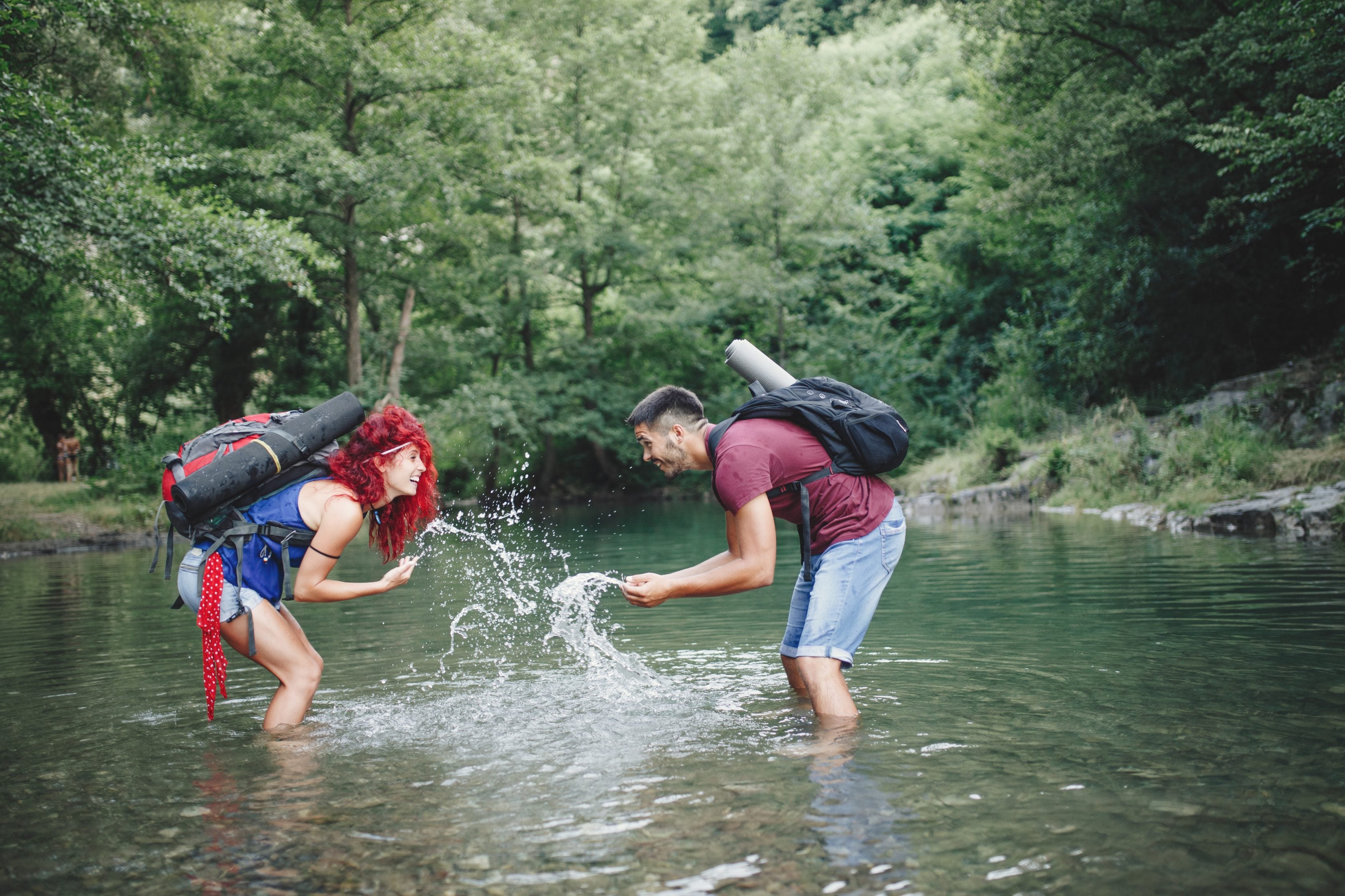 Happy hikers couple enjoying in wild mountain river